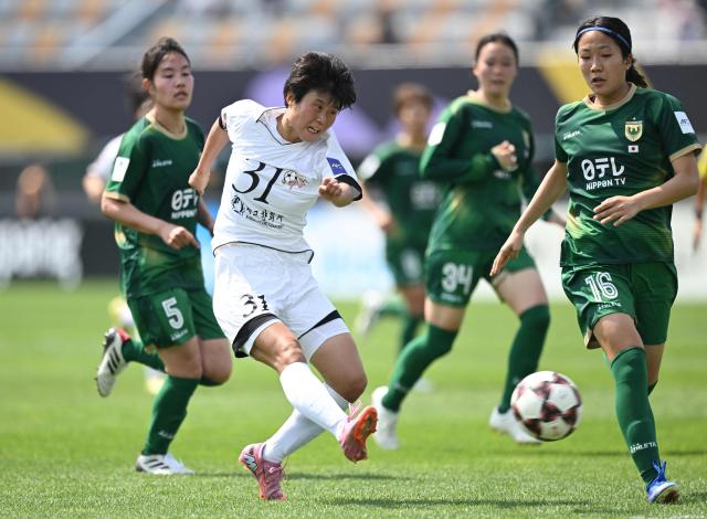 Jong Kum (C) of Naegohyang Women's FC shoots the ball against Tokyo Verdy Beleza during the AFC Women's Champions League final football match between North Korea's Naegohyang Women's FC and Japan's Tokyo Verdy Beleza in Suwon on May 23, 2026. (Photo by JUNG YEON-JE / AFP)