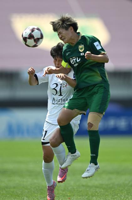 Jong Kum (L) of Naegohyang Women's FC fights for the ball with Tomoko Muramatsu (R) of Tokyo Verdy Beleza during the AFC Women's Champions League final football match between North Korea's Naegohyang Women's FC and Japan's Tokyo Verdy Beleza in Suwon on May 23, 2026. (Photo by JUNG YEON-JE / AFP)