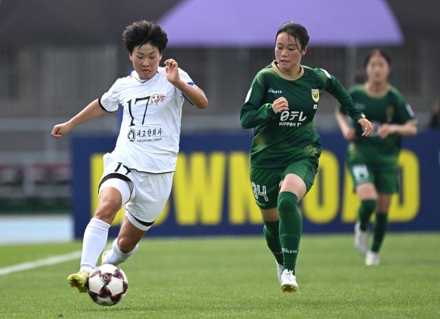 Kim Kyong Yong (L) of Naegohyang Women's FC fights for the ball with Tamami Aso (R) of Tokyo Verdy Beleza during the AFC Women's Champions League final football match between North Korea's Naegohyang Women's FC and Japan's Tokyo Verdy Beleza in Suwon on May 23, 2026. (Photo by JUNG YEON-JE / AFP)