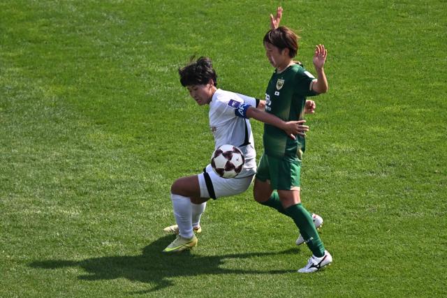 North Korea's Naegohyang Women's FC forward Kim Kyong Yong (L) vies for the ball with Japan's Tokyo Verdy Beleza midfielder Rin Sumida during the AFC Women's Champions League final football match between North Korea's Naegohyang Women's FC and Japan's Tokyo Verdy Beleza at Suwon Sports Complex in Suwon on May 23, 2026. (Photo by Pedro Pardo / AFP)