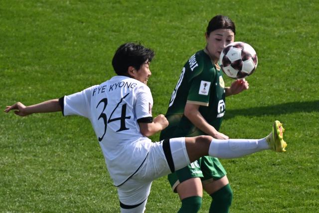 North Korea's Naegohyang Women's FC midfielder Pak Ye Gyong (R) vies for the ball with  Japan's Tokyo Verdy Beleza midfielder Yuzuho Shiokoshi during the AFC Women's Champions League final football match between North Korea's Naegohyang Women's FC and Japan's Tokyo Verdy Beleza at Suwon Sports Complex in Suwon on May 23, 2026. (Photo by Pedro Pardo / AFP)