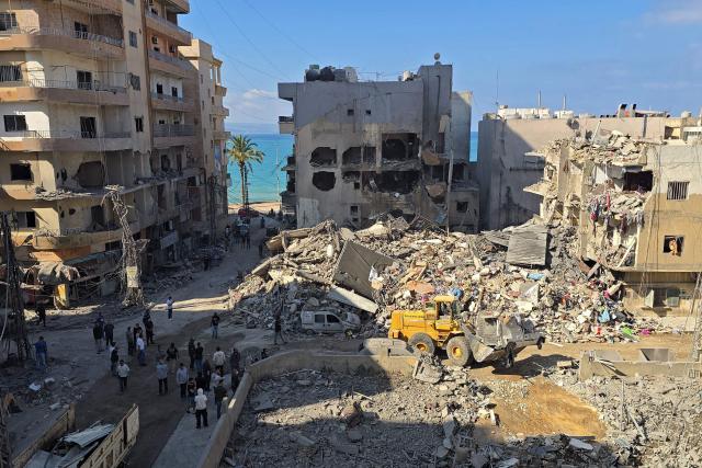People inspect the site of an Israeli strike in the southern Lebanese coastal city of Tyre on May 23, 2026. Two buildings in and around Tyre were struck overnight on May 22 into May 23, after the Israeli military issued an evacuation warning. (Photo by KAWNAT HAJU / AFP)