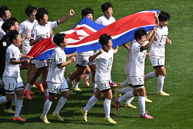 North Korea's Naegohyang Women's FC players celebrate after defeating Japan's Tokyo Verdy Beleza in the AFC Women's Champions League final at Suwon Sports Complex in Suwon on May 23, 2026. (Photo by Pedro Pardo / AFP)