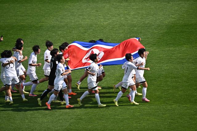 North Korea's Naegohyang Women's FC players celebrate after defeating Japan's Tokyo Verdy Beleza in the AFC Women's Champions League final at Suwon Sports Complex in Suwon on May 23, 2026. (Photo by Pedro Pardo / AFP)