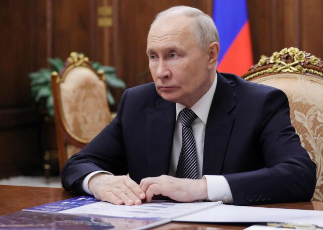 In this pool photograph distributed by the Russian state agency Sputnik, Russia's President Vladimir Putin looks on as he attends a meeting with the Head of the Tyva Republic in Moscow on May 22, 2026. (Photo by Mikhail METZEL / POOL / AFP)
