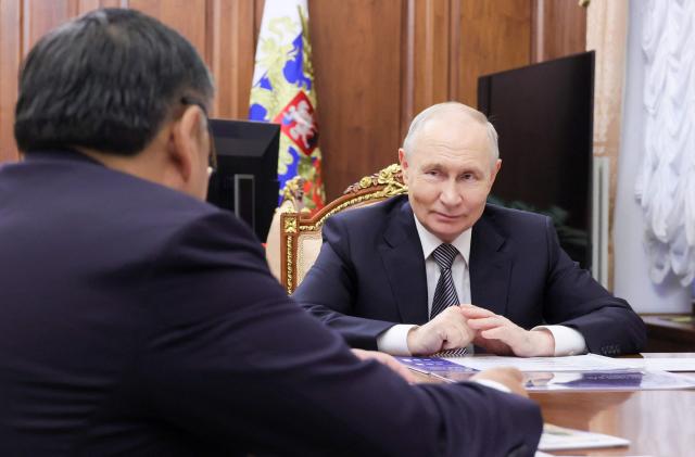 In this pool photograph distributed by the Russian state agency Sputnik, Russia's President Vladimir Putin reacts as he attends a meeting with the Head of the Tyva Republic in Moscow on May 22, 2026. (Photo by Mikhail METZEL / POOL / AFP)