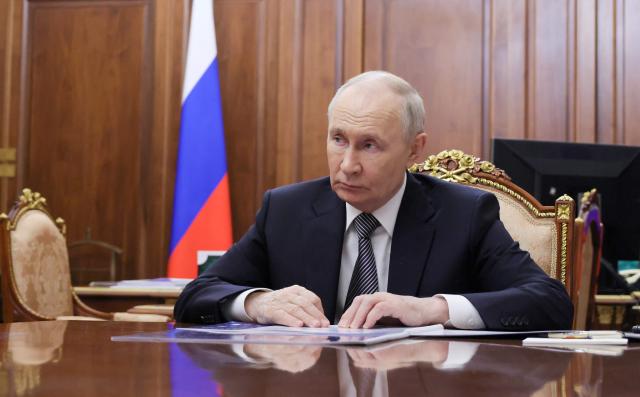 In this pool photograph distributed by the Russian state agency Sputnik, Russia's President Vladimir Putin looks on as he attends a meeting with the Head of the Tyva Republic in Moscow on May 22, 2026. (Photo by Mikhail METZEL / POOL / AFP)