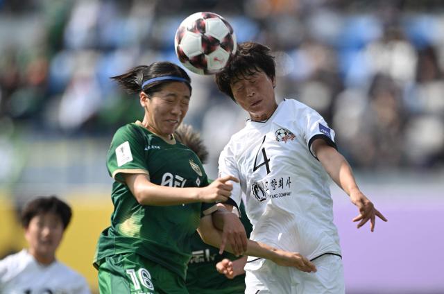 Ri Myong Gum (R) of Naegohyang Women's FC fights for the ball with Yuna Aoki (L) of Tokyo Verdy Beleza during the AFC Women's Champions League final football match between North Korea's Naegohyang Women's FC and Japan's Tokyo Verdy Beleza in Suwon on May 23, 2026. (Photo by Jung Yeon-je / AFP)