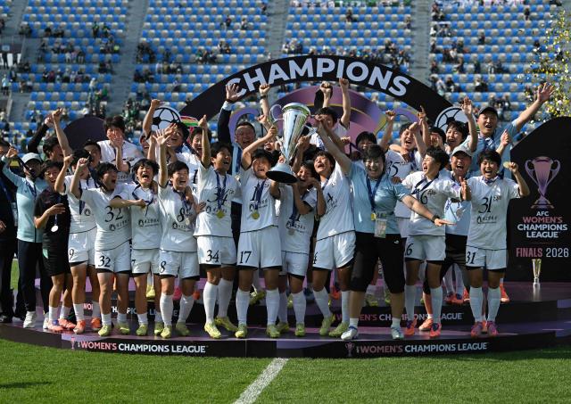 Naegohyang Women's FC players celebrate with the trophy during the victory ceremony after the AFC Women's Champions League final football match between North Korea's Naegohyang Women's FC and Japan's Tokyo Verdy Beleza in Suwon on May 23, 2026. (Photo by Jung Yeon-je / AFP)
