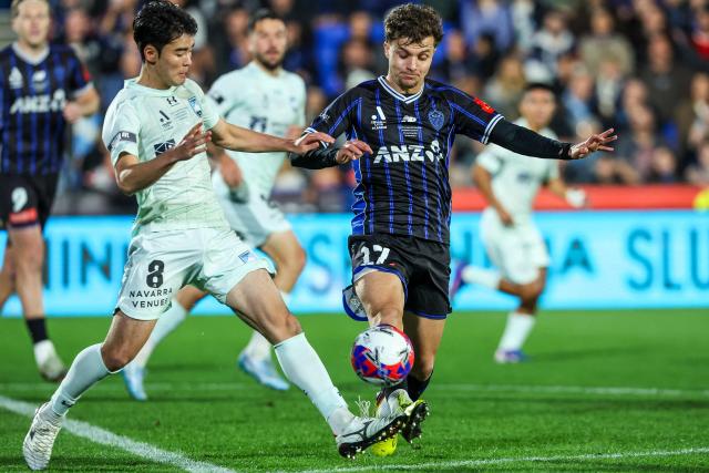 Sydney FC's Wataru Kamijo (L) and Auckland FC's Callan Elliot (R) fight for the ball during the A League Grand final football match between Auckland FC and Sydney FC at Go Media Stadium in Auckland on May 23, 2026. (Photo by DJ MILLS / AFP)