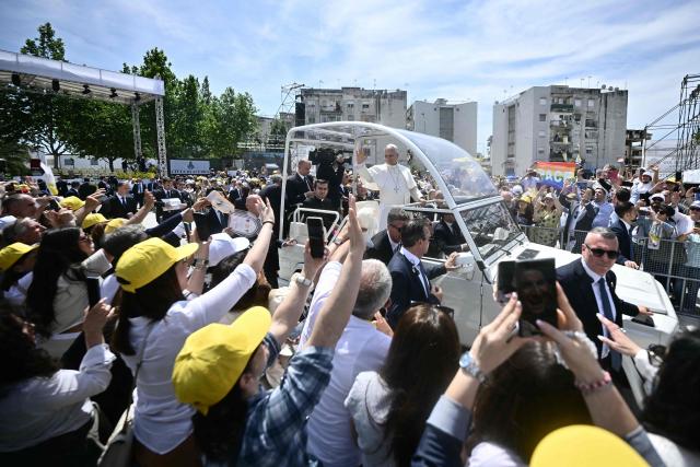 Pope Leo XIV waves to the crowd from the popemobile at Piazza Nicola Calipari at the end of a pastoral visit to the community of the 'Land of Fires' on May 23, 2026. The Land of Fires (terra dei fuochi) is an area in the Southern Italian region of Campania were, systematically, since the end of the 80s, toxic wastes have been dumped by organized crime (Camorra) causing waste-related environmental crimes. Acerra and the surrounding territory has higher-than-average cancer rates, linked to the dumping, burning, and burying of toxic waste. (Photo by Filippo MONTEFORTE / AFP)