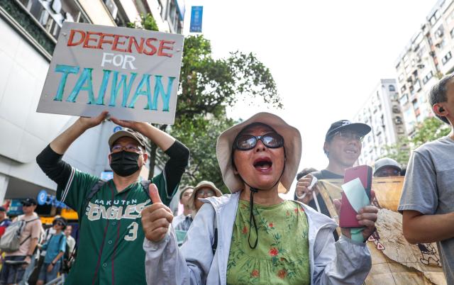 Protestors shout "Want peace, support arms purchases" during a rally to oppose a scaled-down defense budget passed by the legislature in Taipei on May 23, 2026. The budget act removed five major military equipment items proposed in the Cabinet's proposed package. (Photo by I-Hwa Cheng / AFP)