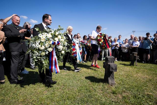 People lay down wreaths as they attend an event organised by the "Union of Expellees within the Christian Social Union party" (UdVA, Union der Vertriebenen, Aussiedler und Deutschen Minderheiten der CSU) to commemorate the flight and expulsion of Sudeten Germans during and after World War II, on May 23, 2026 in Pohorelice, South Moravia, Czech Republic. (Photo by Radek MICA / AFP)