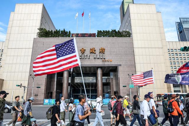 Protestors hold US national flags during a rally to oppose a scaled-down defence budget passed by the legislature in Taipei on May 23, 2026. The budget act removed five major military equipment items proposed in the Cabinet's proposed package. (Photo by I-Hwa Cheng / AFP)