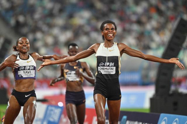 Uganda's Peruth Chemutai (R) celebrates after crossing the finish line to win ahead of Bahrain's Winfred Yavi (L) in the women's 3000m steeplechase final event during the Xiamen Diamond League athletics meeting at Egret Stadium in Xiamen, in China’s eastern Fujian province on May 23, 2026. (Photo by Hector RETAMAL / AFP)