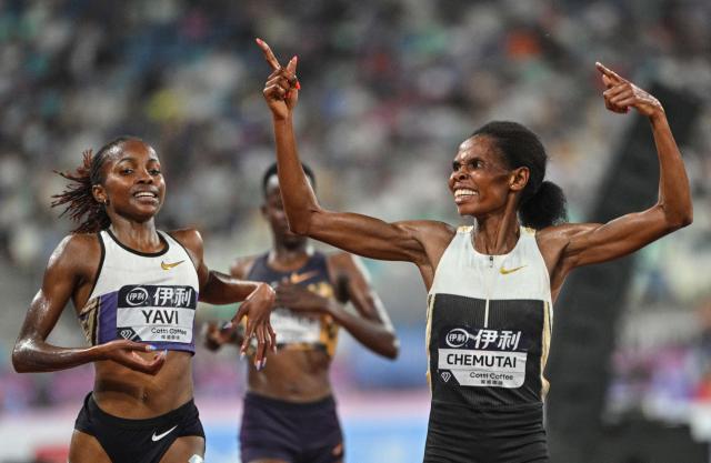 Uganda's Peruth Chemutai (R) celebrates after crossing the finish line to win ahead of Bahrain's Winfred Yavi (L) in the women's 3000m steeplechase final event during the Xiamen Diamond League athletics meeting at Egret Stadium in Xiamen, in China’s eastern Fujian province on May 23, 2026. (Photo by Hector RETAMAL / AFP)