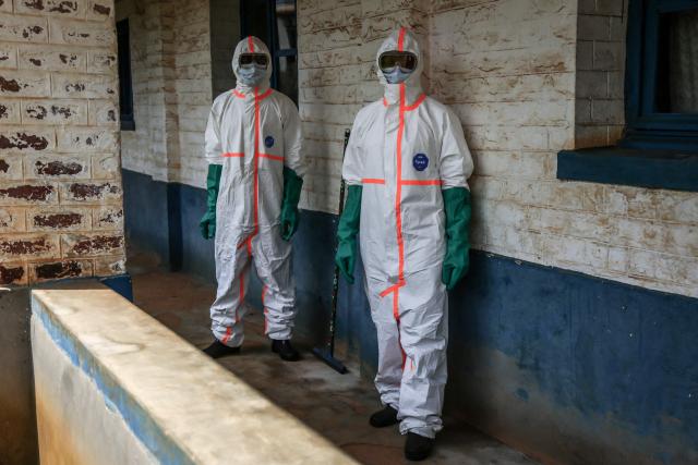 TOPSHOT - Health workers wearing protective equipment gather to disinfect the isolation area for Ebola patients at the General Referral Hospital of Mongbwalu in Mongbwalu, on May 23, 2026. Ebola continues to spread in Democratic Republic of Congo, where the first cases of transmission were reported in the eastern province of South Kivu, while the health response is struggling to get organized and has given rise to scenes of chaos in Ituri province, the epicenter of the epidemic. The World Health Organization (WHO) issued an international health alert to address a 17th Ebola outbreak in the east of the Democratic Republic of Congo, a vast Central African country of more than 100 million inhabitants plagued by conflict. (Photo by Seros MUYISA / AFP)