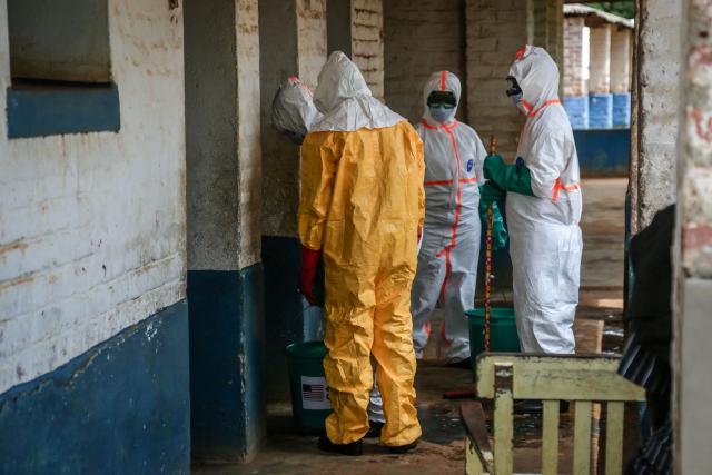 Health workers wearing protective equipment disinfect the isolation area for Ebola patients at the General Referral Hospital of Mongbwalu in Mongbwalu, on May 23, 2026. Ebola continues to spread in Democratic Republic of Congo, where the first cases of transmission were reported in the eastern province of South Kivu, while the health response is struggling to get organized and has given rise to scenes of chaos in Ituri province, the epicenter of the epidemic. The World Health Organization (WHO) issued an international health alert to address a 17th Ebola outbreak in the east of the Democratic Republic of Congo, a vast Central African country of more than 100 million inhabitants plagued by conflict. (Photo by Seros MUYISA / AFP)