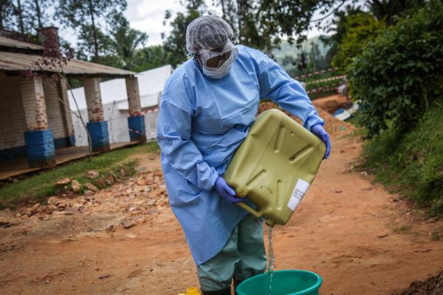 A health worker wearing protective equipment prepares disinfectant materials as she gets ready to disinfect the isolation area for Ebola patients at the General Referral Hospital of Mongbwalu in Mongbwalu, on May 23, 2026. Ebola continues to spread in Democratic Republic of Congo, where the first cases of transmission were reported in the eastern province of South Kivu, while the health response is struggling to get organized and has given rise to scenes of chaos in Ituri province, the epicenter of the epidemic. The World Health Organization (WHO) issued an international health alert to address a 17th Ebola outbreak in the east of the Democratic Republic of Congo, a vast Central African country of more than 100 million inhabitants plagued by conflict. (Photo by Seros MUYISA / AFP)