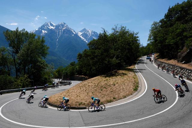 Riders take a curve during the 14th stage of the Giro d'Italia 2026 - Tour of Italy cycling race between Aosta and Pila (Gressan), Italy, on May 23, 2026. (Photo by Luca Bettini / AFP)