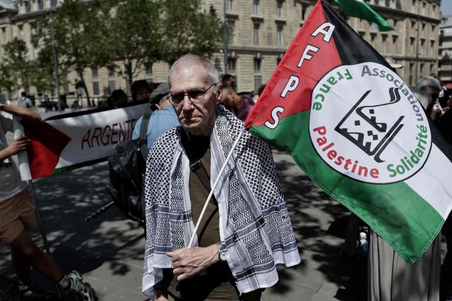A demonstrator holds a flag of the Association France Palestine Solidarite (AFPS) as French activists of the Global Sumud Gaza-bound flotilla and protesters gather to take part in a demonstration in solidarity with Palestinians, to condemn the interception of the Global Sumud Flotilla by the Israeli army, at the Place de la Republique in Paris on May 23, 2026. The 37 French nationals were among some 430 activists from 40 countries aboard the Global Sumud Flotilla, intercepted by the Israeli navy in international waters on May 18, 2026 in the latest string of attempts to break the blockade of the Palestinian territory. (Photo by STEPHANE DE SAKUTIN / AFP)