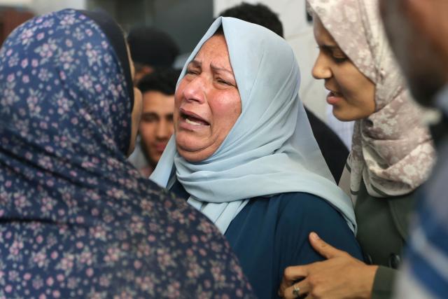 Palestinian comfort each other as the bodies of several people brought to the al-Shifa Hospital are taken for burial, in Gaza City on May 23, 2026, after Israeli airstrike targeted a police post in the Al-Tuam area, west of Jabalia in the northern Gaza Strip. An Israeli strike killed five police officers in the northern Gaza Strip on May 23, said a hospital and the Palestinian territory's police force, which operates under Hamas authority. A ceasefire has been in place since October 2025, but Israel reserves the right to strike targets it deems a threat. (Photo by Omar AL-QATTAA / AFP)