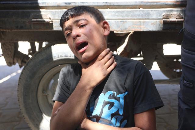 A Palestinian mourner reacts as the bodies of several people brought to the al-Shifa Hospital are taken for burial, in Gaza City on May 23, 2026, after Israeli airstrike targeted a police post in the Al-Tuam area, west of Jabalia in the northern Gaza Strip. An Israeli strike killed five police officers in the northern Gaza Strip on May 23, said a hospital and the Palestinian territory's police force, which operates under Hamas authority. A ceasefire has been in place since October 2025, but Israel reserves the right to strike targets it deems a threat. (Photo by Omar AL-QATTAA / AFP)