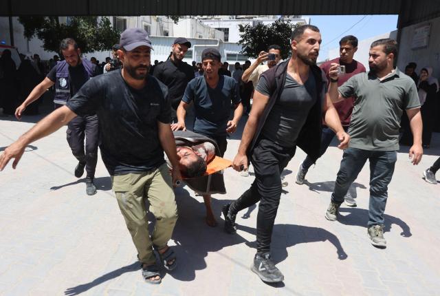 Palestinian mourners carry a body for burial from the al-Shifa Hospital in Gaza City on May 23, 2026, after Israeli airstrike targeted a police post in the Al-Tuam area, west of Jabalia in the northern Gaza Strip. An Israeli strike killed five police officers in the northern Gaza Strip on May 23, said a hospital and the Palestinian territory's police force, which operates under Hamas authority. A ceasefire has been in place since October 2025, but Israel reserves the right to strike targets it deems a threat. (Photo by Omar AL-QATTAA / AFP)