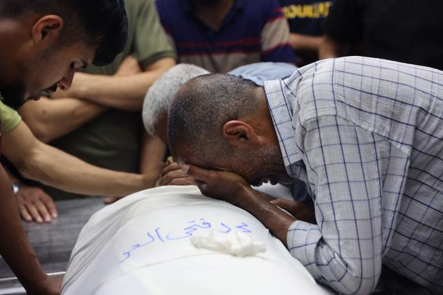 A Palestinian mourner reacts over the body of one of several people brought to the al-Shifa Hospital prior to their funeral, in Gaza City on May 23, 2026, after Israeli airstrike targeted a police post in the Al-Tuam area, west of Jabalia in the northern Gaza Strip. An Israeli strike killed five police officers in the northern Gaza Strip on May 23, said a hospital and the Palestinian territory's police force, which operates under Hamas authority. A ceasefire has been in place since October 2025, but Israel reserves the right to strike targets it deems a threat. (Photo by Omar AL-QATTAA / AFP)