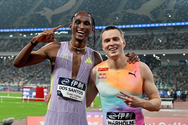 Winner Brazil's Alison Dos Santos (L) celebrates with second-placed Norway's Karsten Warholm at the end of the men's 400m hurdles final event during the Xiamen Diamond League athletics meeting at Egret Stadium in Xiamen, in China’s eastern Fujian province on May 23, 2026. (Photo by Hector RETAMAL / AFP)