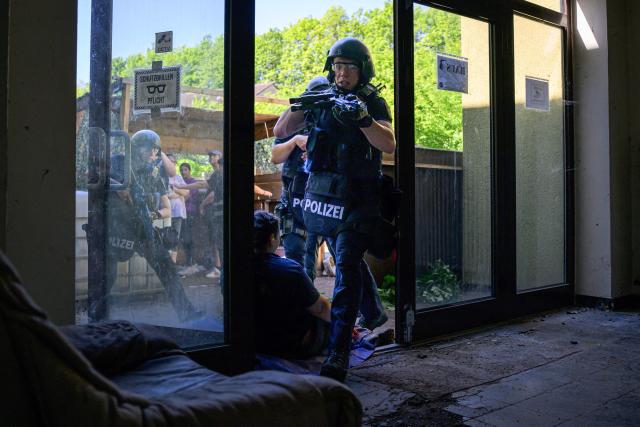 Police officers enter a building during an emergency drill involving police, German Red Cross rescue workers and emergency responders, on May 23, 2026 in Bad Sobernheim, Rhineland-Palatinate, western Germany. (Photo by Hannes P. Albert / AFP)