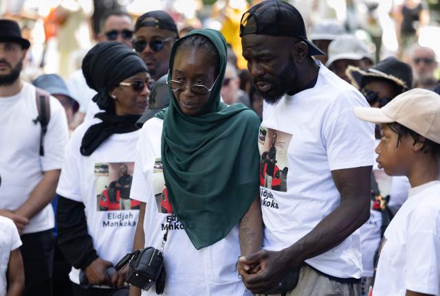 Olga Mankoka (C), Felix Mankoka (2R) hold hands as they take part in a silent march in tribute to their son Elidjah Mankoka in Nantes, western France on May 23, 2026, after his death by shooting on May 14. The death of fifteen year-old Elidjah along with the wounding of two other minors on the same day, took place in the Port-Boyer neighbourhood on the western French city, which had already been hit by deadly shootings linked to drug trafficking earlier in the year. (Photo by Fred TANNEAU / AFP)