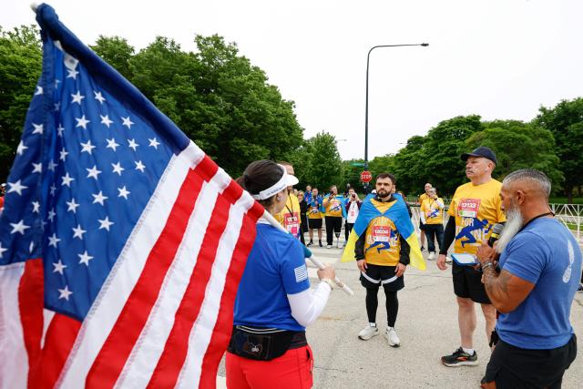 Active-duty Ukrainian service member Andrii Savenko (C) and former Deputy Minister of Defense of Ukraine, retired Major General Volodymyr Havrylov (2-R) participate in the annual Soldier Field 10 race and other commemorative activities to honor fallen American and Ukrainian service members during a Memorial Day tribute in Chicago, on May 23, 2026. Active-duty Ukrainian soldiers participate in the annual Soldier Field 10 race and other commemorative activities to honor fallen American and Ukrainian service members during a Memorial Day tribute in Chicago, on May 23, 2026. (Photo by KAMIL KRZACZYNSKI / AFP)
