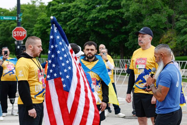 Active-duty Ukrainian service members Serhii Zozulia (L), Andrii Savenko (C) and former Deputy Minister of Defense of Ukraine, retired Major General Volodymyr Havrylov (2-R) participate in the annual Soldier Field 10 race and other commemorative activities to honor fallen American and Ukrainian service members during a Memorial Day tribute in Chicago, on May 23, 2026. Active-duty Ukrainian soldiers participate in the annual Soldier Field 10 race and other commemorative activities to honor fallen American and Ukrainian service members during a Memorial Day tribute in Chicago, on May 23, 2026. (Photo by KAMIL KRZACZYNSKI / AFP)