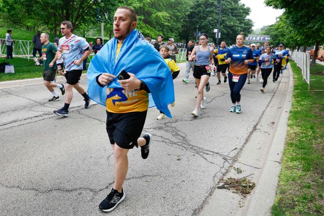 Active-duty Ukrainian service member Serhii Zozulia runs in the annual Soldier Field 10 race and other commemorative activities to honor fallen American and Ukrainian service members during a Memorial Day tribute in Chicago, on May 23, 2026. Active-duty Ukrainian soldiers participate in the annual Soldier Field 10 race and other commemorative activities to honor fallen American and Ukrainian service members during a Memorial Day tribute in Chicago, on May 23, 2026. (Photo by KAMIL KRZACZYNSKI / AFP)