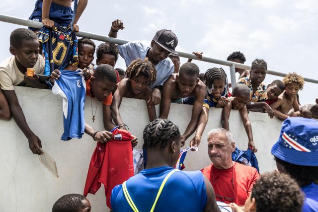 TOPSHOT - Supporters wait to have their t-shirts signed by Cape Verde’s defender Sidny Lopes Cabral (C) at the end of a training session to prepare for their participation in the 2026 FIFA World Cup at Estadio Municipal 25 de Julho in Santa Cruz, on May 23, 2026. (Photo by PATRICK MEINHARDT / AFP)