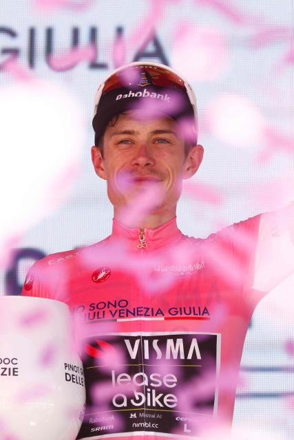 Team Visma Lease a Bike Danish rider Jonas Vingegaard celebrates the overall leader's pink jersey on the podium after winning the 14th stage of the Giro d'Italia 2026 - Tour of Italy cycling race between Aosta and Pila (Gressan), Italy, on May 23, 2026. (Photo by Luca Bettini / AFP)
