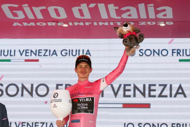 Team Visma Lease a Bike Danish rider Jonas Vingegaard celebrates the overall leader's pink jersey on the podium after winning the 14th stage of the Giro d'Italia 2026 - Tour of Italy cycling race between Aosta and Pila (Gressan), Italy, on May 23, 2026. (Photo by Luca Bettini / AFP)