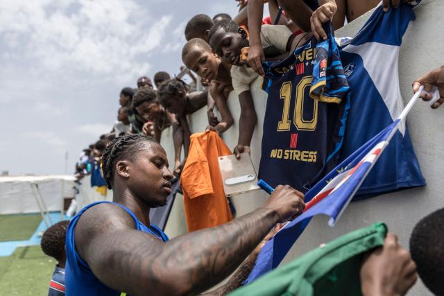 Cape Verde’s defender Sidny Lopes Cabral signs a Cape Verdean flag at the end of a training session to prepare for their participation in the 2026 FIFA World Cup at Estadio Municipal 25 de Julho in Santa Cruz, on 23 May 2026. (Photo by PATRICK MEINHARDT / AFP)