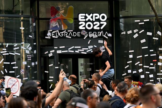 People put stickers reading "students are winning" on the windows of the Expo 2027 headquarters building front entrance during an anti-government protest decrying corruption and calling for early elections following the collapse of a railway station canopy in Novi Sad that killed 16 in November 2024, in central Belgrade on May 23, 2026. (Photo by OLIVER BUNIC / AFP)