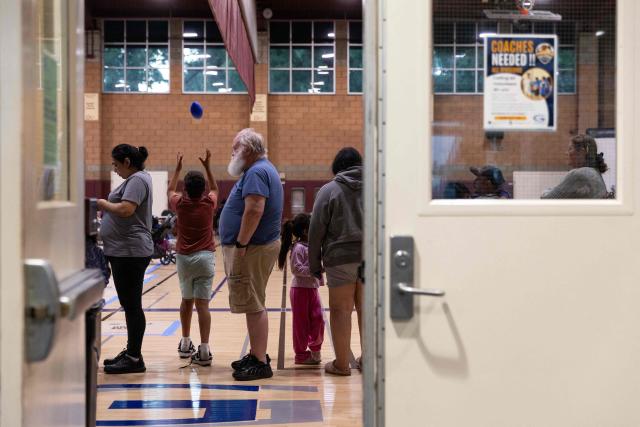 (FILES) Evacuees wait in line for food after a chemical leak from a large storage tank threatened residents in Garden Grove, California on May 22, 2026. Tens of thousands of people were ordered to leave their homes in California Friday after a huge chemical tank began leaking, with warnings it might blow up, sending toxic fumes over a heavily populated area. (Photo by Blake Fagan / AFP)