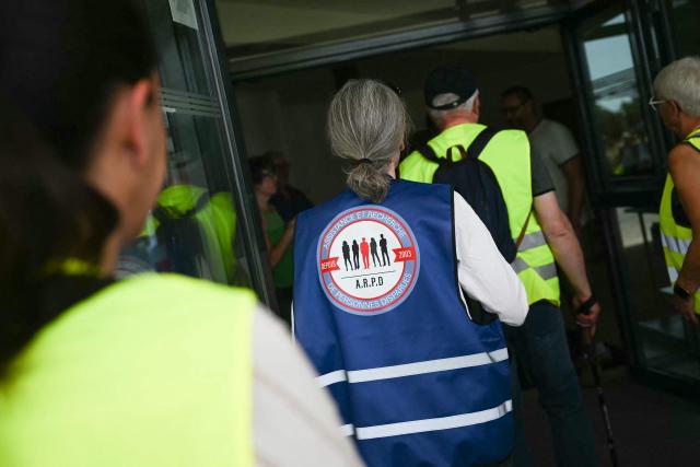 A volunteer wears a chasuble from the Assistance and Search for Missing Persons (A.R.P.D) association as she participate in a community search in Saint-Étienne-de-Montluc, western France on May 23, 2026, as they look for information relating to Manon Relandeau, who has been missing since March 27. Some 300 volunteers combed the area on the outskirts of Nantes in an effort to find clues relating to the 31-year-old farmer who has been missing for nearly two months. (Photo by Lou BENOIST / AFP)