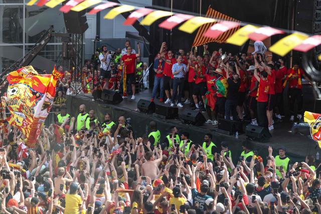 RC Lens' players celebrate on stage with supporters on the Place Jean Jaures following the club's victory in the French Cup final football match against OGC Nice, in Lens, northern France on May 23, 2026. (Photo by FRANCK FIFE / AFP)