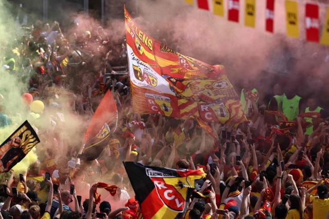 RC Lens supporters wave flags and burn flares as they gather on the Place Jean-Jaures during celebrations following the club's victory in the French Cup final football match against OGC Nice, in Lens, northern France on May 23, 2026. (Photo by FRANCK FIFE / AFP)
