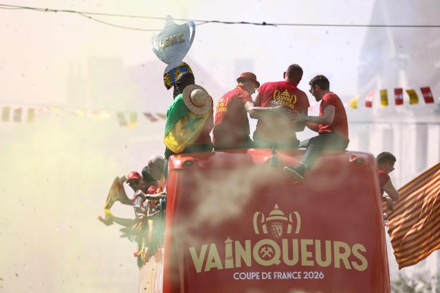 RC Lens' players parade for supporters atop a double-decker bus during celebrations following their victory in the French Cup final football match against OGC Nice, in Lens, northern France on May 23, 2026. (Photo by FRANCK FIFE / AFP)
