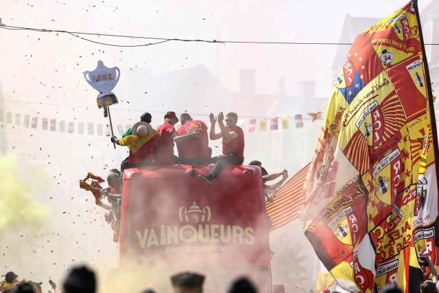 RC Lens' players parade for supporters atop a double-decker bus during celebrations following their victory in the French Cup final football match against OGC Nice, in Lens, northern France on May 23, 2026. (Photo by FRANCK FIFE / AFP)