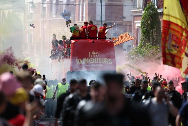 RC Lens' players parade for supporters atop a double-decker bus during celebrations following their victory in the French Cup final football match against OGC Nice, in Lens, northern France on May 23, 2026. (Photo by FRANCK FIFE / AFP)