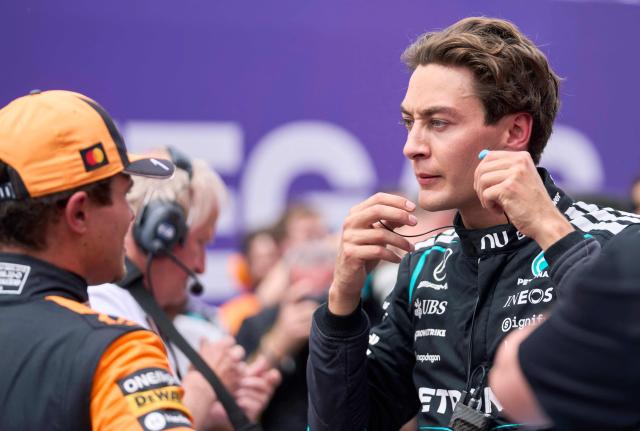 Mercedes' British driver George Russell (R) removes his earplugs to speak with second place McLaren's British driver Lando Norris after winning the Sprint race ahead of the 2026 Formula 1 Grand Prix du Canada at Circuit Gilles-Villeneuve in Montreal, Canada, on May 23, 2026. (Photo by Geoff Robins / AFP)