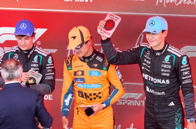 First place Mercedes' British driver George Russell (R), second place McLaren's British driver Lando Norris (C) and third place Mercedes' Italian driver Kimi Antonelli receive their plaques after the Sprint race ahead of the 2026 Formula 1 Grand Prix du Canada at Circuit Gilles-Villeneuve in Montreal, Canada, on May 23, 2026. (Photo by Geoff Robins / AFP)