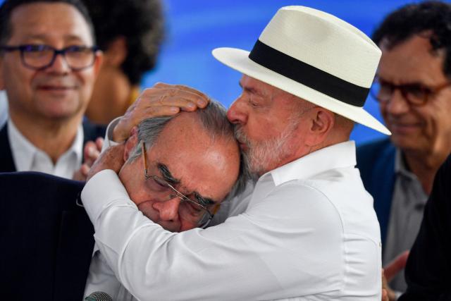 Brazil's President Luiz Inacio Lula da Silva (R) kisses the forehead of scientist Carlos Morel, director of the Center for Technological Development in Health at Fiocruz (CDTS), during the inauguration of the Center for Technological Development in Health (CDTS/Fiocruz) and the launch of the Center for Development and Production of CAR-T Therapies, which will allow national production of cell therapies at reduced prices, at Fiocruz in Rio de Janeiro, Brazil, on May 23, 2026. (Photo by Daniel RAMALHO / AFP)